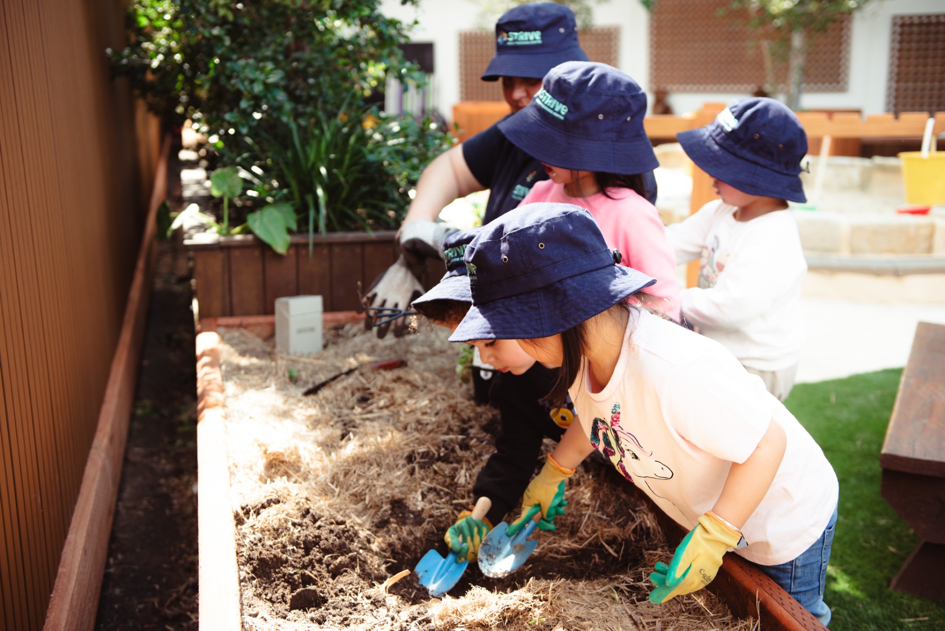 Children planting seeds in the garden bed