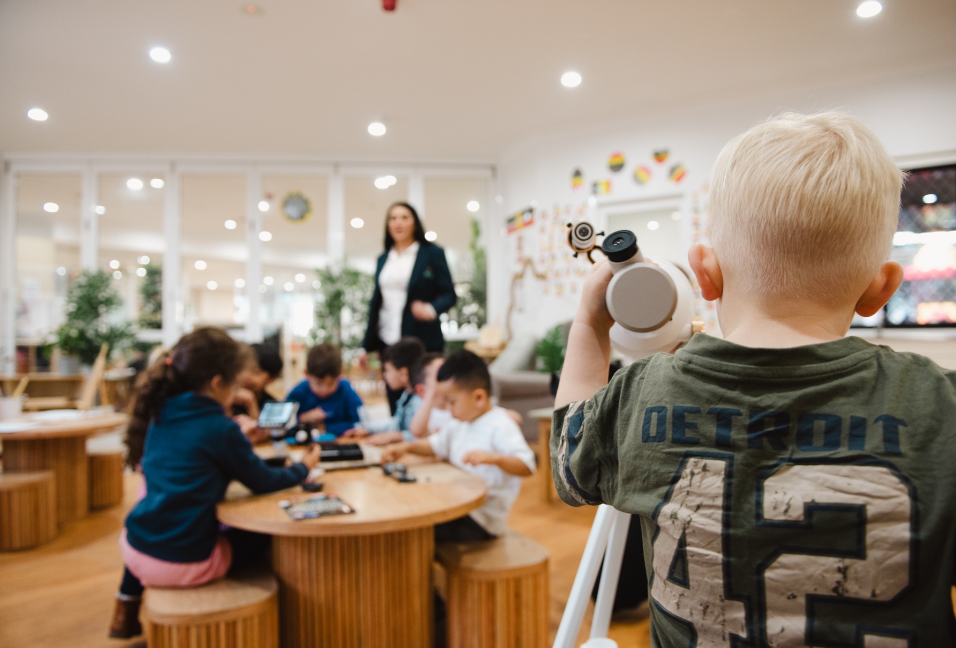 Child looking through a telescope in the classroom