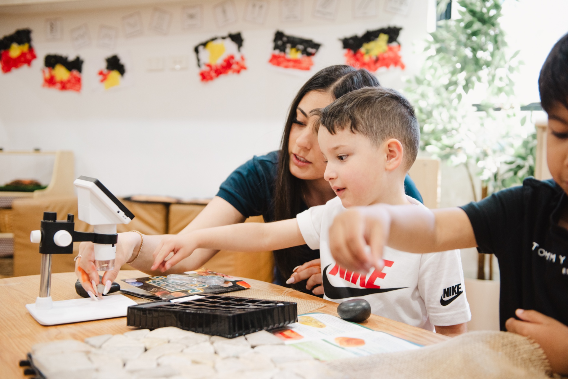Educator and child exploring with a digital microscope