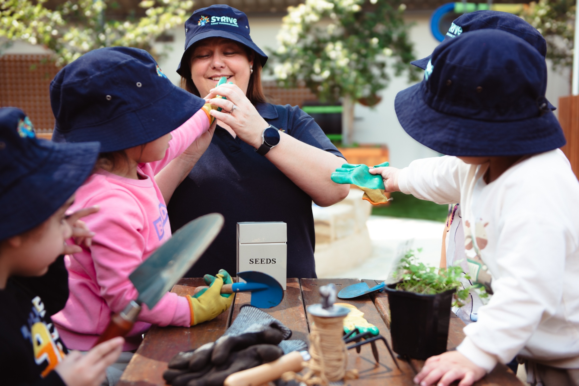 Educator gardening with children at Strive