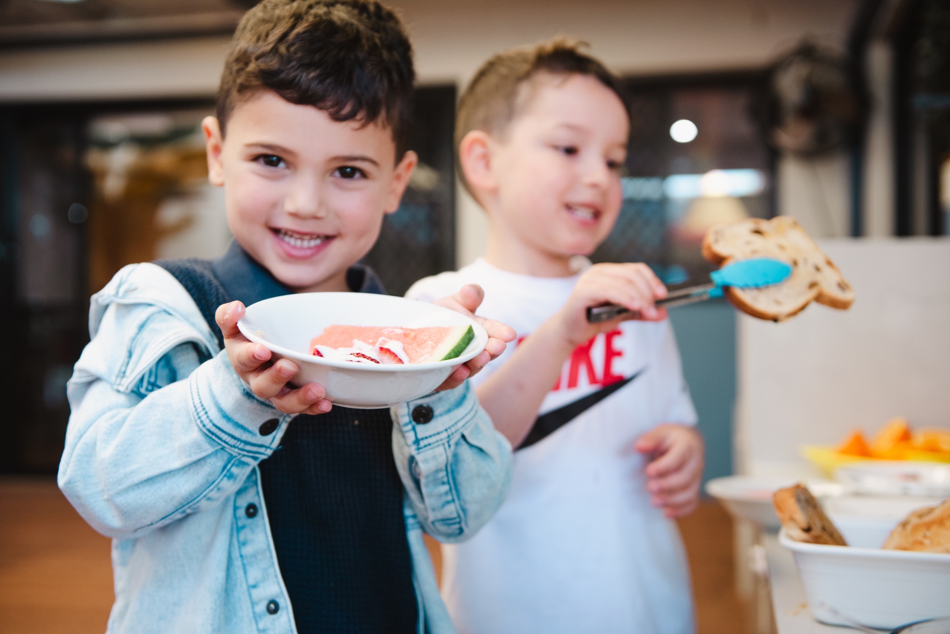 Two children sharing fruit and bread at snack time