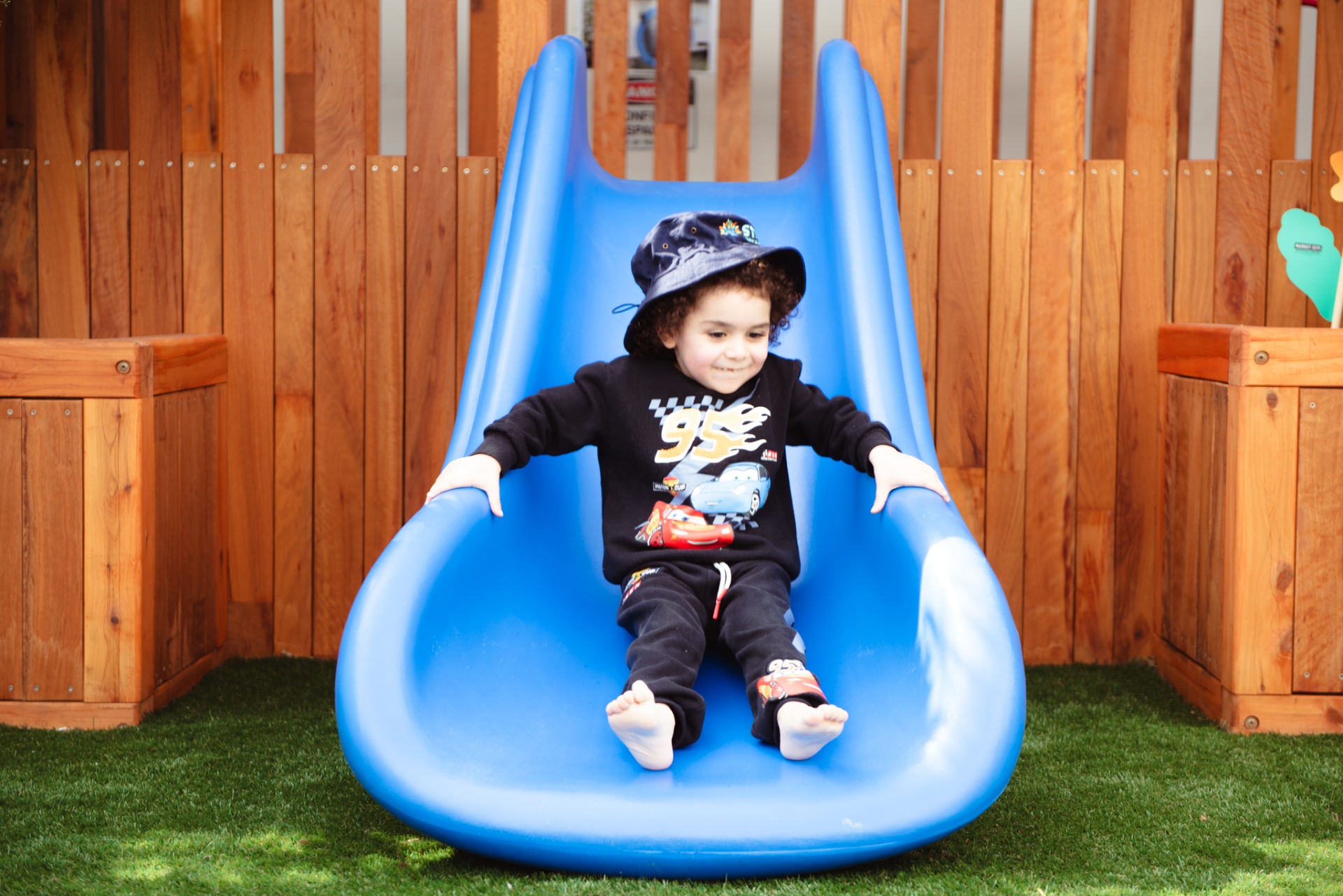Child sliding down the blue slide