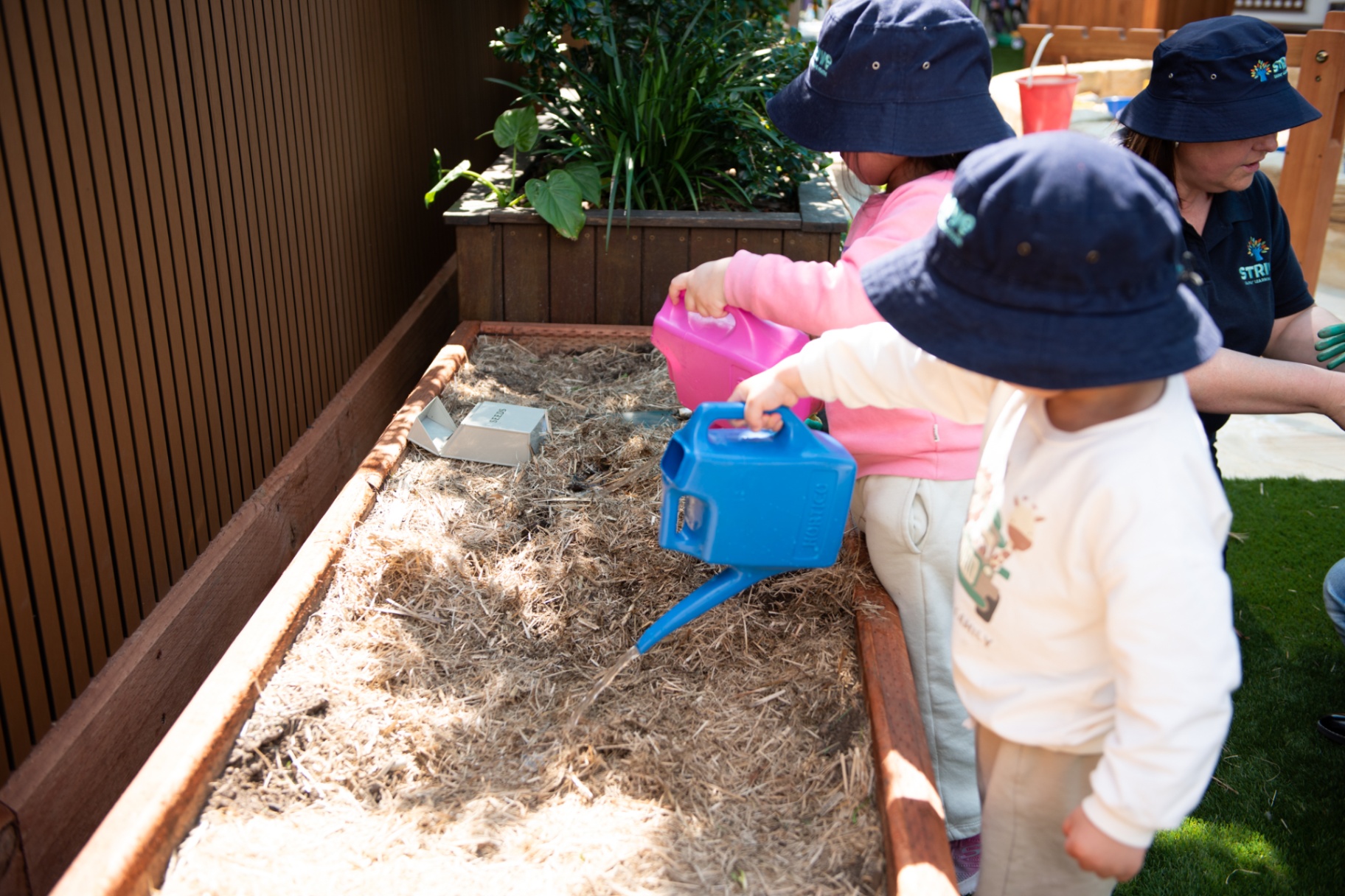 Children watering the garden bed